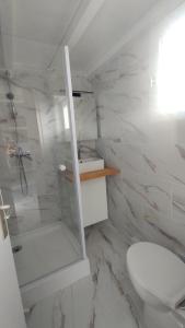 a white bathroom with a shower and a toilet at Appartement T2 en résidence Naturiste en bord de Mer in Leucate-Plage +32 photos