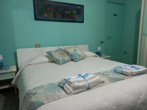 a bedroom with a bed with towels on it at B&B La casa di Dorothy in Telti