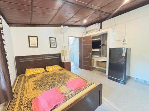 a bedroom with a large bed and a kitchen at Studio Arambol Escape R-8 by Mukund Sadan Arambol in Arambol
