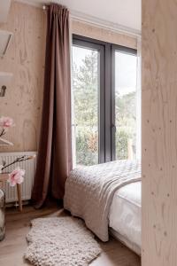 ヌンスペートにあるUltiem ontspannen in luxe en design ingericht tiny house in bosrijke omgevingのベッドルーム1室(ベッド1台、大きな窓付)