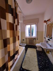 a bathroom with a sink and a tub and a toilet at Villa dei Pini in Laveno-Mombello