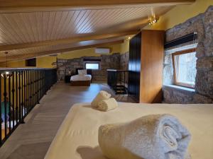 a bedroom with two beds and a stone wall at Moinhos da Pereira - Turismo Rural in Tarouca