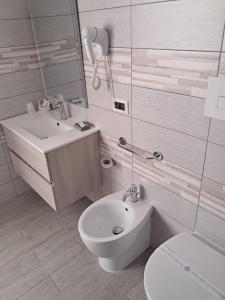 a white bathroom with a toilet and a sink at Hotel Palace Gioia Tauro in Gioia Tauro