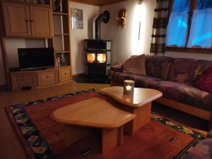 a living room with a couch and a table with a candle at Alpenrose Aletsch Landschaftspark Binntal in Grengiols