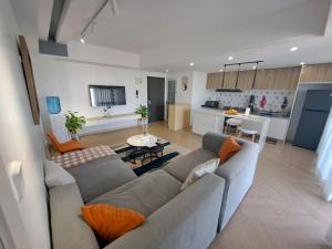 a living room with a couch and a kitchen at Modern 1BR Apartment in Upperhill, Nairobi in Nairobi