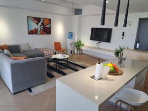 a living room with a couch and a kitchen with a table at Modern 1BR Apartment in Upperhill, Nairobi in Nairobi