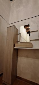 a room with a staircase with a mirror and a cabinet at La Casetta di Minù in Cosenza