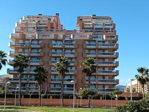 a tall building with palm trees in front of it at Apartamento Giovanni - Marina D'Or in El Borseral
