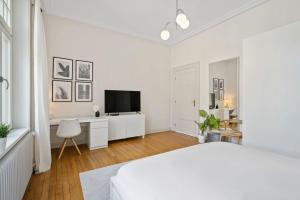 una camera bianca con letto e scrivania di Spacious & Tranquil Rooms in Limpertsberg a Lussemburgo
