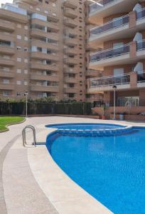 a swimming pool in front of a building at Apartamento Giovanni - Marina D'Or in El Borseral