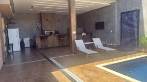 a living room with a table and chairs and a kitchen at Pérola de Geribá in Búzios