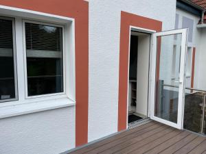 a house with two windows and a deck at Ferienwohnung Diemelblick in Trendelburg
