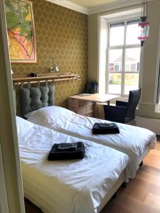 a bedroom with a bed with two black towels on it at B&B Moleneind Pieterburen in Pieterburen