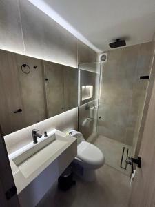 バランキージャにあるModern new apartment in Barranquillaの洗面台、トイレ、鏡のあるバスルーム