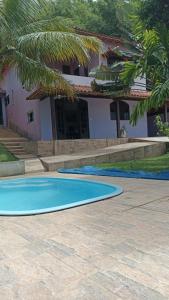 a swimming pool in front of a house at Casa de campo vista para a Lagoa in Saquarema