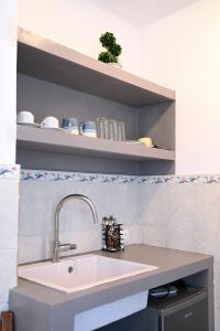 a kitchen counter with a sink and shelves at Oneiro Rooms Kythnos in Kanala +35 photos