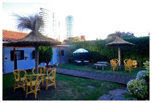 a yard with chairs and tables and umbrellas at Hotel Los Ángeles in Mar del Plata