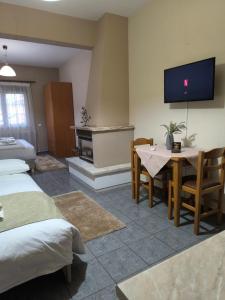 a room with two beds and a table and a tv at Guesthouse Platon in Órma