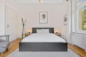 una camera da letto con un grande letto bianco e una finestra di Spacious & Tranquil Rooms in Limpertsberg a Lussemburgo