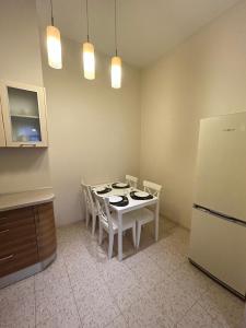 a kitchen with a white table with chairs and a refrigerator at OLD TOWN Republika - 2 rooms - Self Check In - 24 hours - Free parking in Liepāja