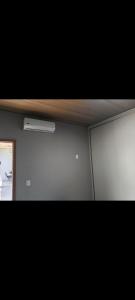 a room with a white wall and a window at Edícula com churrasqueira in Foz do Iguaçu