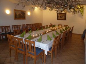 een lange tafel met groene servetten en stoelen in een kamer bij Landgasthof Düllhof in Schaufling