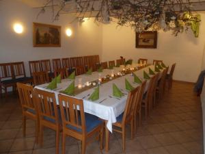 una mesa larga con servilletas verdes y sillas en una habitación en Landgasthof Düllhof en Schaufling