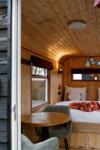 a bedroom with a bed and a table in a room at CRASH'NSTAY - Juffrouw Jansen in Hooge Vaart