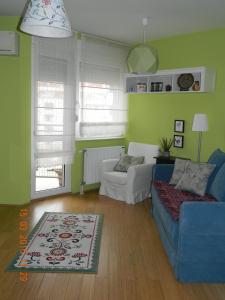 een woonkamer met een blauwe bank en een stoel bij Apartment Dunja in Novi Sad