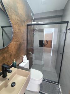a bathroom with a shower and a toilet and a sink at Suíte 24 família Praia de Leste in Pontal do Paraná