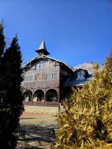 un grande edificio con una torre in cima di Casa La Buni a Buşteni