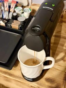 a coffee maker is pouring coffee into a cup at The Crescent Guest House in York