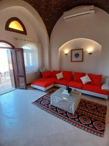 a living room with a red couch and a table at Rihana 2 bedrooms in Hurghada