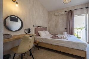 a bedroom with a bed and a mirror and a chair at Iviskos - Adults Only in Laganas +7 photos