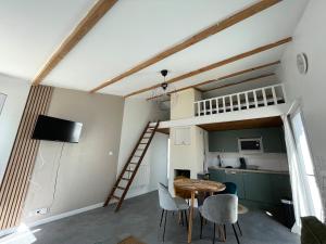 a room with a loft bed and a table and chairs at Maisonnette Le Galet Jaune in Bretignolles-sur-Mer