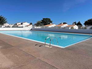 a large swimming pool with blue water at Maisonnette Le Galet Jaune in Bretignolles-sur-Mer