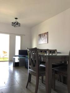 a living room with a wooden table and chairs at 2BR Amwaj Terrazza & Piscina in Marsa Matruh