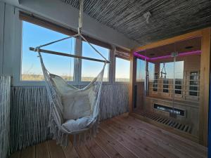 a hammock hanging in a room with a large window at Stylish Forest View - Apartment in Augsburg