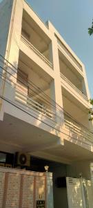 a white building with a balcony on top of it at Hotel Abhi family guest house in Lucknow