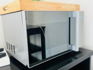Un horno microondas colocado encima de una encimera. en Cosy Nest - Uncapped Wi-fi & Self Check-in, en Ciudad del Cabo