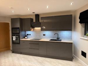 a kitchen with gray cabinets and a sink at 267 Stylish 2 Bed Apartment City Centre Free Parking in Cardiff