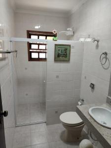 a bathroom with a shower and a toilet and a sink at Casa na Boraceia, 100 M praia c roupas cama e banho in São Sebastião