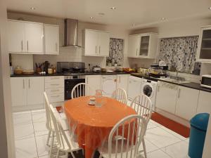 a kitchen with an orange table and chairs in a kitchen at High Street House WEST BROMWICH in West Bromwich