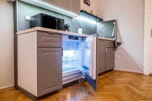 a kitchen with an empty refrigerator and a microwave at Budapest Grand Danube Suite in Budapest +16 photos