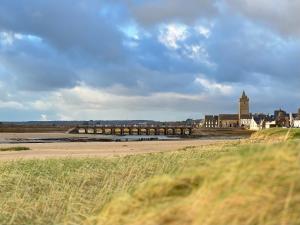 a view of a city with a bridge and buildings at Au petit Cachou in Port-Bail-sur-Mer