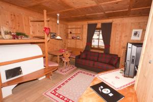 a living room with a couch and a bed in a cabin at Apartments Mauriz in Selva di Val Gardena