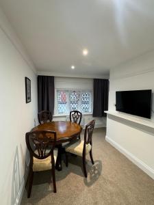 a dining room with a table and chairs and a television at City Centre House in Southampton