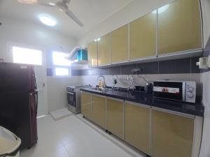 eine Küche mit Spüle und Mikrowelle in der Unterkunft NOVA Apartment in Ma‘ābīlah