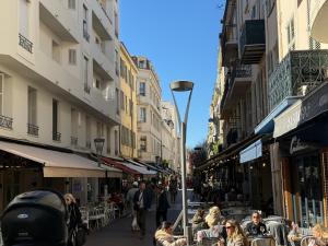 a busy city street with people sitting at tables at Appartement HOCHE CANNES centre-ville in Cannes