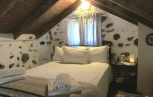 a bedroom with a white bed and a window at Angela's River Paradise Cottages in Mixórrouma